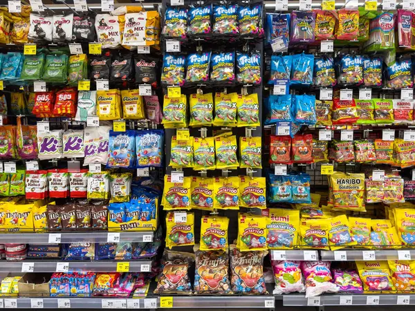 Süpermarket rafında renkli paketlenmiş şeker çeşitleri.