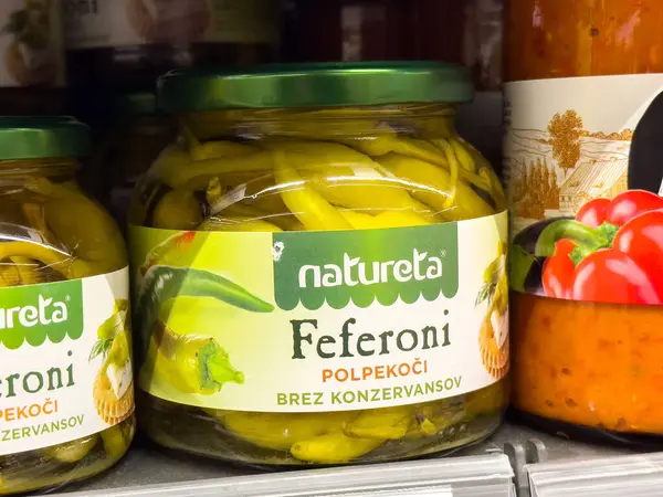 Dolgun etiket tasarımı ve renkli arkaplan içeren turşulu biber kavanozu..