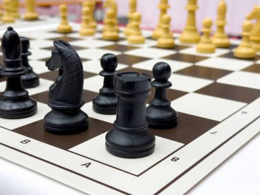 Stratejik formda siyah-beyaz satranç taşlarıyla satranç tahtasının yakın çekimi.