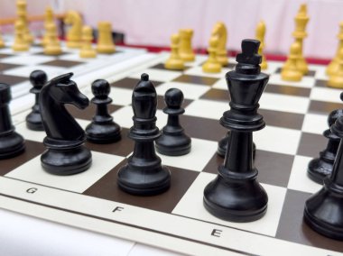 Siyah ve beyaz taşlarla yoğun bir satranç oyunu.