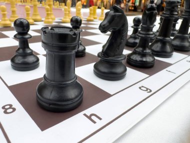 Oyun sırasında kareli bir tahtaya siyah satranç taşlarının yakın plan görüntüsü.