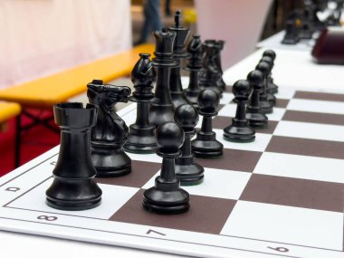 Yoğun stratejik oyun için gemide siyah satranç taşları düzenlendi.