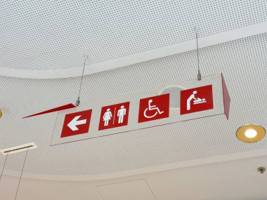 Cinsiyet, engellilik ve bebek değiştirme simgeleriyle tuvaletler ve erişilebilirlik tabelaları.