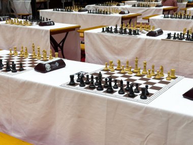 Çoklu oyun tabloları ve tahtaları olan satranç turnuvası kurulumu.