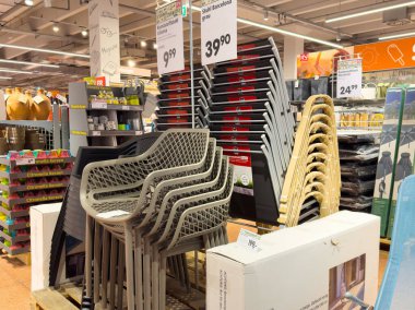 Yığınlanmış teras sandalyeleri ve bahçe malzemelerinin modern perakende sergilenişi.