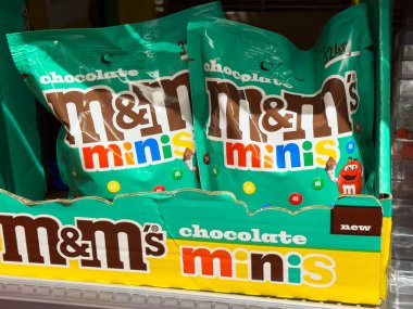 Marketteki raflarda M & M 'nin çikolatalı mini şeker torbaları.