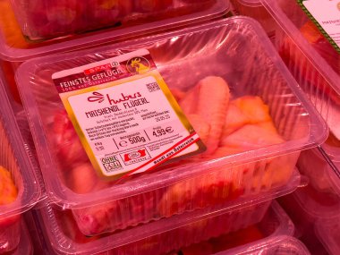 Markette kırmızı ışıkta paketlenmiş tavuk kanatları..