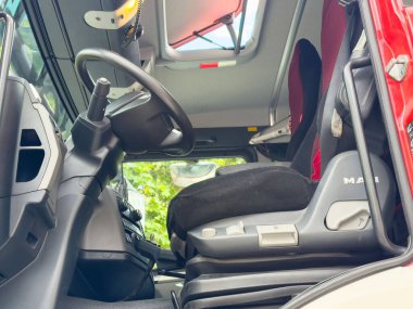 Modern kırmızı kamyon kabin içi koltuk ve direksiyon gösteriyor..