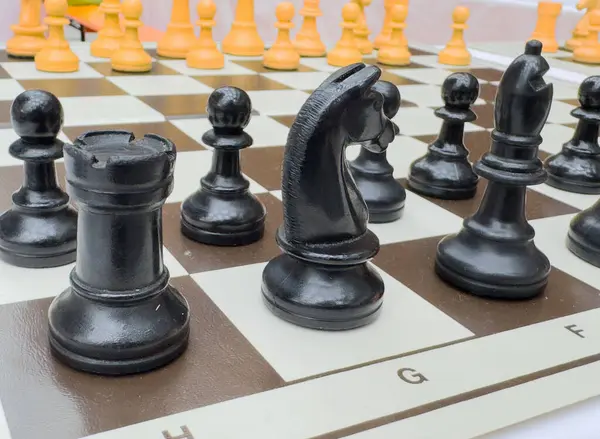 Açık hava oyunu sırasında satranç tahtasındaki satranç taşlarının yakın plan görüntüsü.