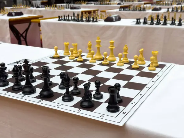 Satranç turnuvası. Tahta masalarda siyah ve beyaz parçalar var..