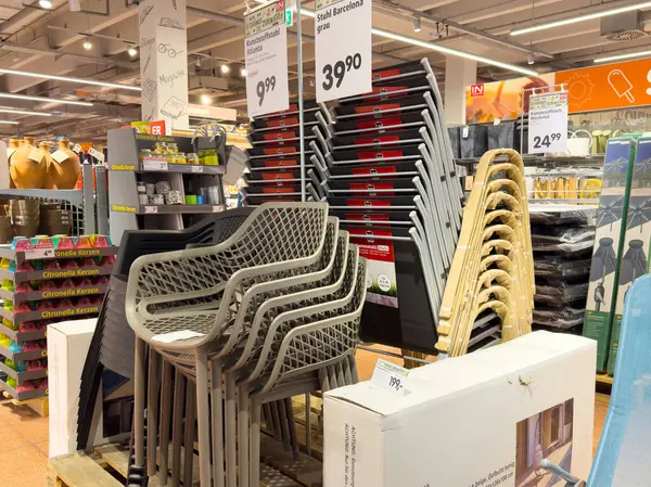 Yığınlanmış teras sandalyeleri ve bahçe malzemelerinin modern perakende sergilenişi.