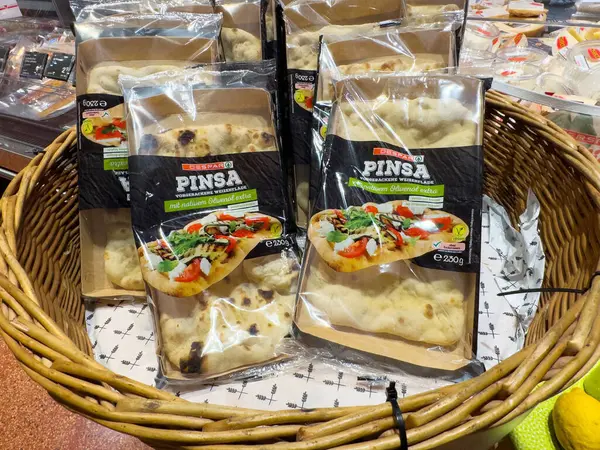 Süpermarket sepetinde taze sebzelerle birlikte çeşitli pinsa paketleri..