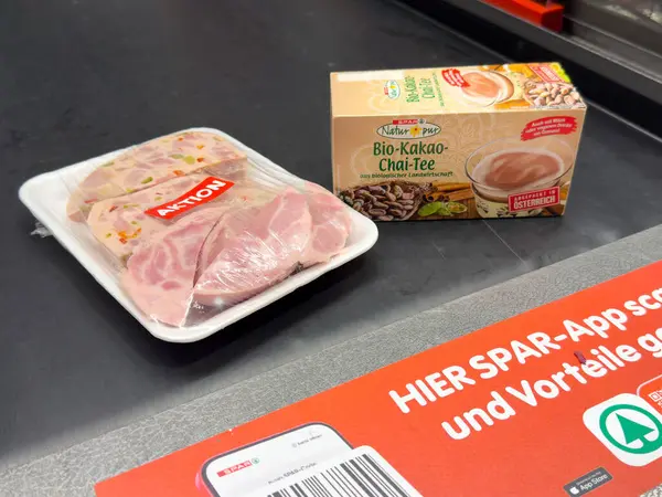 Süpermarket taşıma bandında paketlenmiş domuz pirzolası ve organik çay..