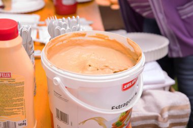 Açık havada büyük bir konteynır estragon sosu ahşap masada toplanıyor..