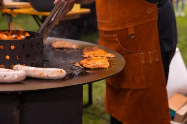 Açık havada ızgara et ve ateşte sosis ile barbekü..