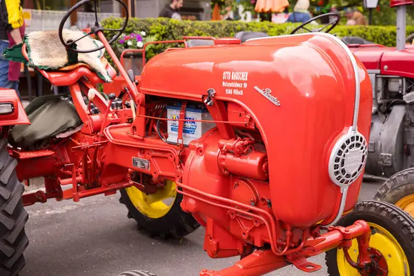 Açık hava sergisinde sarı tekerlekleri olan klasik kırmızı traktör..