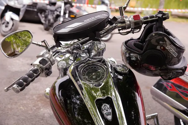 Parlak motosikletli, gidonu açık bir yerde miğferli..