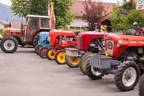 Kırsal bir ortamda güneşli bir günde açık havada gösterilen klasik traktörler..