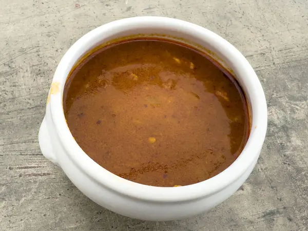 Köy yüzeyinde beyaz kâse içinde baharatlı Hint mercimeği..