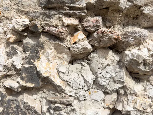 Yıpranmış taş ve kaya yüzeyine dokulu detaylarla yakın çekim.