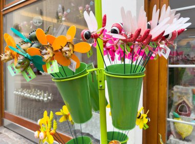 Renkli bahçe süslemeleri: yeşil kovalarda çeşitli sopa çekirgesi süslemeleri.