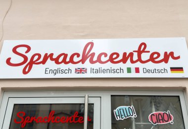 İngilizce, İtalyanca ve Almanca bayrakları sergilenen dil merkezi işareti.