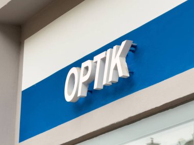 Mavi ve beyaz cephede modern optik mağaza tabelası.