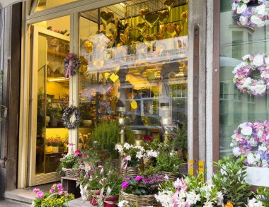 Şehir meydanında renkli çiçekleri ve kalp süslemeleri olan büyüleyici bir çiçekçi..