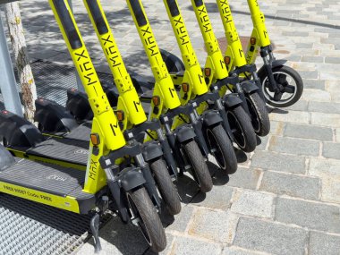 Yeşil kireç rengi scooter 'lar kaldırım taşı sokağına park edilmiş..