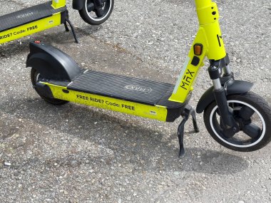 Çakıl taşı yüzeyinde bedava yolculuk kodlu yeşil elektrikli scooterlar..