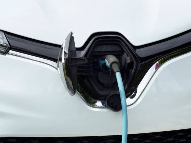 Ön tampon kapağına bağlı elektrikli araba şarjı yakın plan..