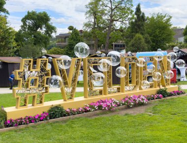 Yeşillik bahçe ortamında hashtag ve şeffaf küreler ile büyük açık hava görüntüsü.