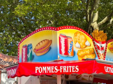 Renkli yiyecek standı, canlandırıcı içecekler ve ağaç gölgesinde atıştırmalıklar..