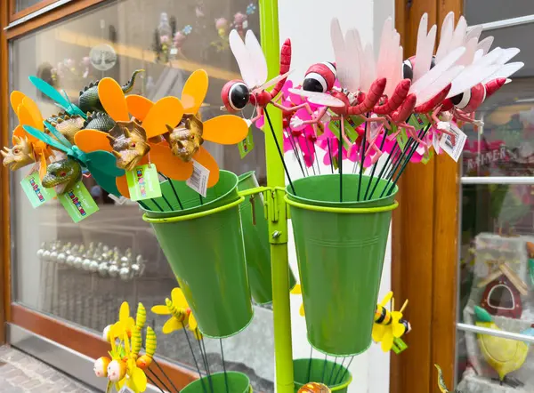 Renkli bahçe süslemeleri: yeşil kovalarda çeşitli sopa çekirgesi süslemeleri.