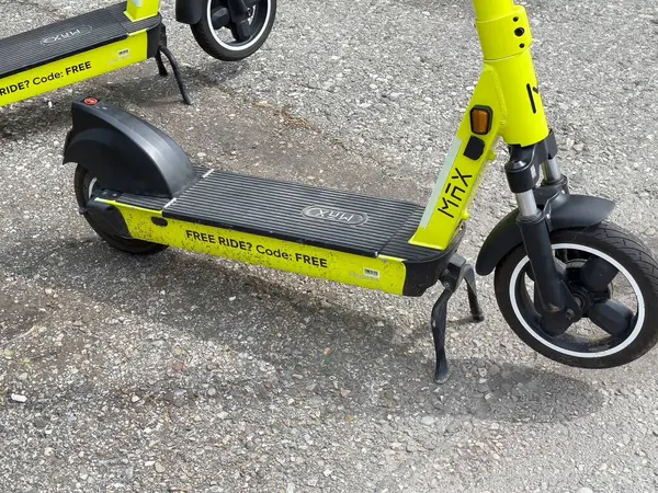 Çakıl taşı yüzeyinde bedava yolculuk kodlu yeşil elektrikli scooterlar..