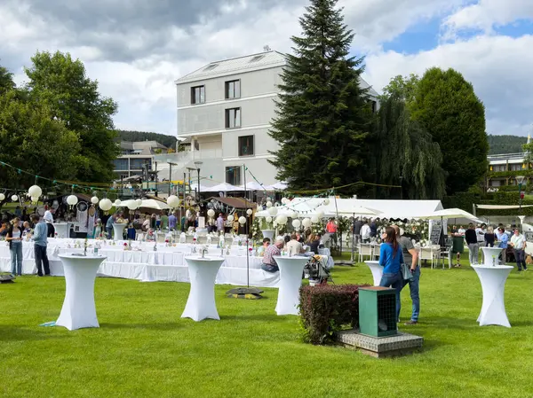 Modern mekanda masalar ve misafirlerle açık hava bahçe partisi..