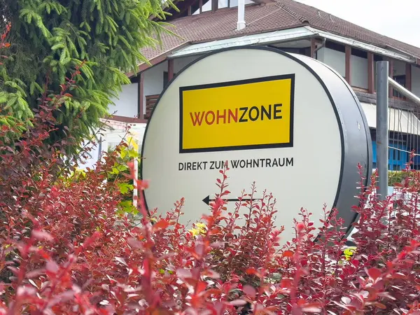 Şehir ortamında kırmızı yapraklarla çevrili wohnzone mağaza tabelasının dış görünümü.