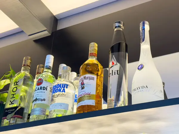 Bar rafında çeşitli içki şişeleri sergileniyor..