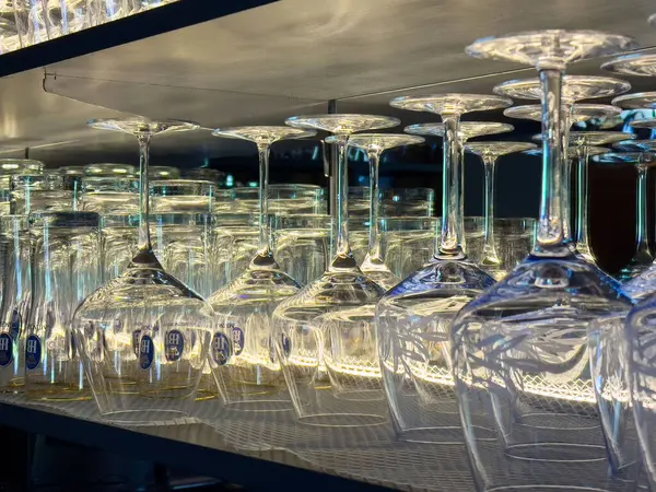 Yansımaları ve aydınlatma efektleri olan bir rafta baş aşağı duran cam..