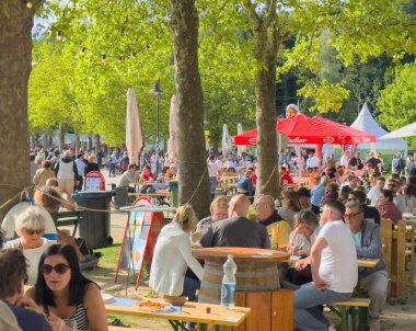 Çeşitli kalabalıklarla açık hava yemek etkinliği. Parkta güneşli bir günün tadını çıkarıyorlar..