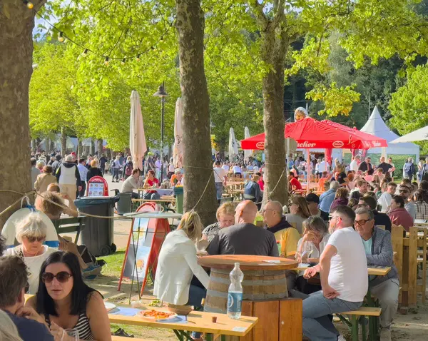 Çeşitli kalabalıklarla açık hava yemek etkinliği. Parkta güneşli bir günün tadını çıkarıyorlar..