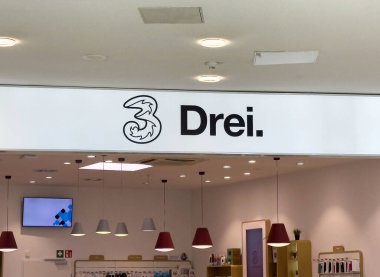 Damga işareti 'drei' ve tavan ışıklandırmasıyla modern mağaza içi.