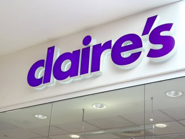 Claire 'in vitrin vitrininde cam üzerinde kalın mor bir logo var..