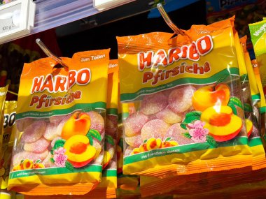 Haribo şeftalili jelibonlar mağazanın rafında parlak turuncu paketlerde..