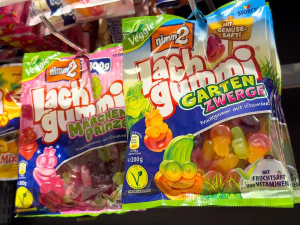 Marketin rafında çeşitli meyve aromalı şeker torbaları sergileniyor..