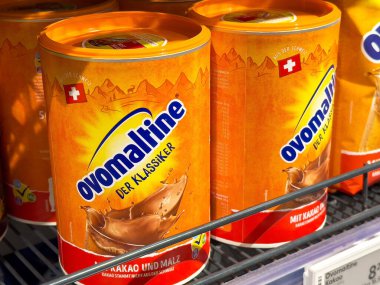 Süpermarket rafında Ovomaltine der klassiker kakao ve malt tozu kutuları.