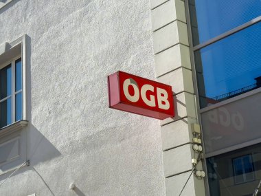 Şehir merkezinde yansıması olan bir duvarda Ogb kırmızı tabelası.