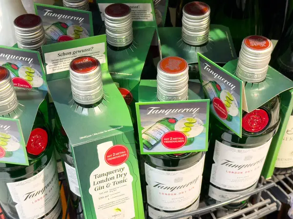 Tanqueray Londrası promosyon etiketleriyle dolu rafta duran kuru cin şişeleri.