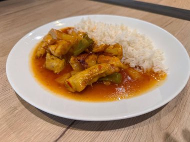 Lezzetli tavuk tatlı ve ekşi pirinç ahşap masada..