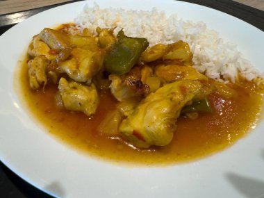 Lezzetli tatlı ve ekşi tavuk ve tabakta beyaz pirinç..